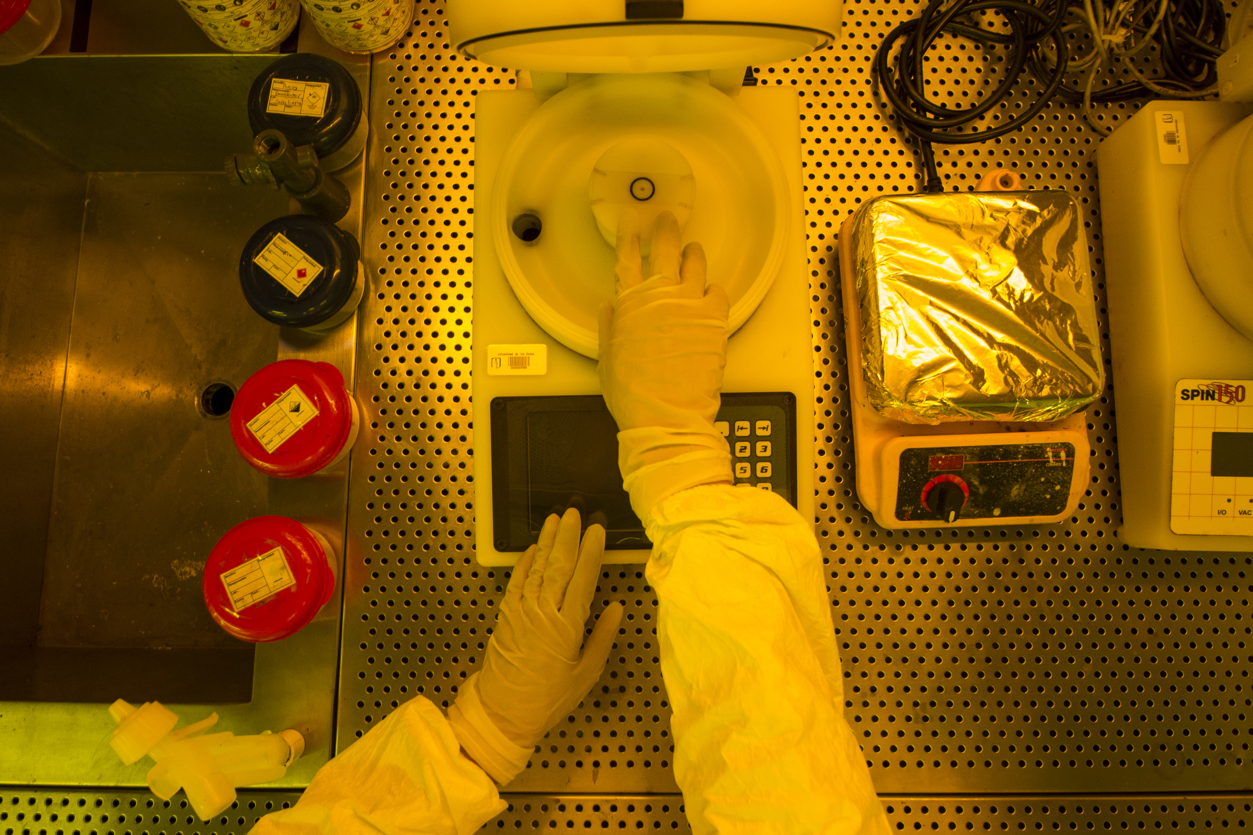 Persona usando guantes de laboratorio manipulando una centrífuga en un entorno estéril.